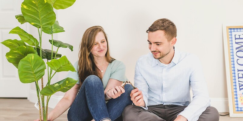 Man and Woman Sitting on the Floor while Holding Keys